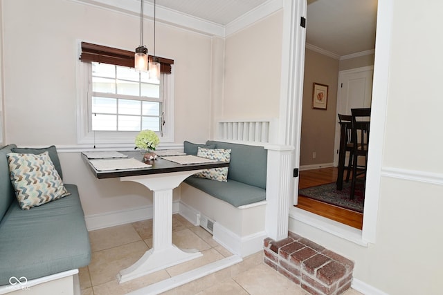 tiled dining room featuring crown molding, baseboards, and breakfast area