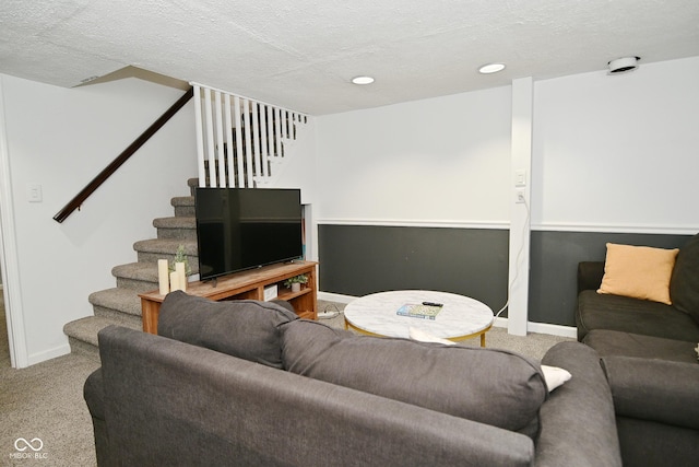 living area with carpet flooring, a textured ceiling, baseboards, and stairs