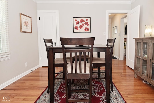 dining area featuring baseboards, ornamental molding, and light wood-style flooring