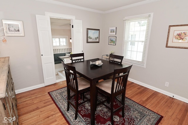 dining space with crown molding, baseboards, and light wood-type flooring