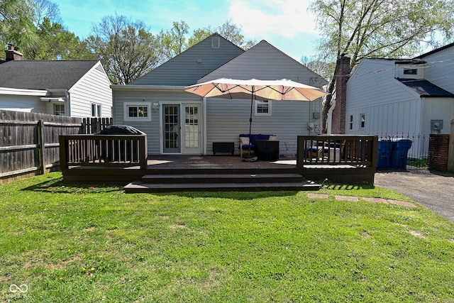 back of house with a yard, a wooden deck, and a fenced backyard