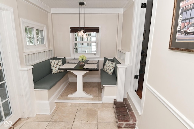 tiled dining area featuring ornamental molding, a chandelier, and breakfast area