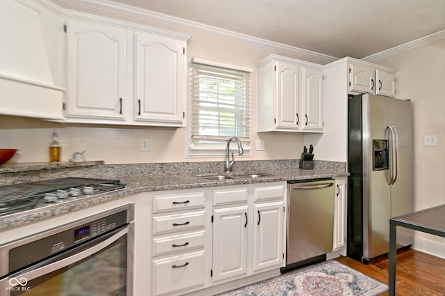 kitchen featuring crown molding, light wood-type flooring, a sink, white cabinets, and stainless steel appliances