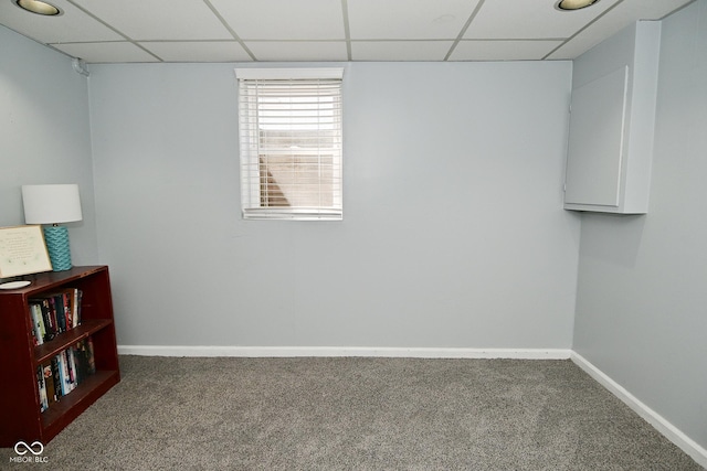 interior space with baseboards, a paneled ceiling, and carpet