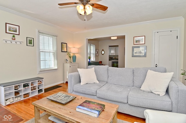 living room featuring light wood-style floors, baseboards, ceiling fan, and ornamental molding