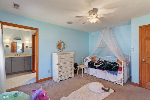 carpeted bedroom with a sink, a ceiling fan, baseboards, ensuite bathroom, and visible vents