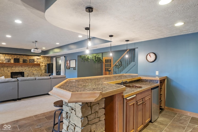bar featuring baseboards, a textured ceiling, decorative light fixtures, and stairway