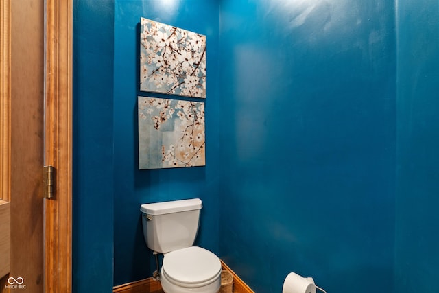 bathroom featuring baseboards and toilet