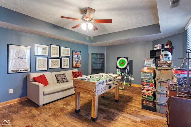 game room featuring baseboards, a textured ceiling, and wood finished floors