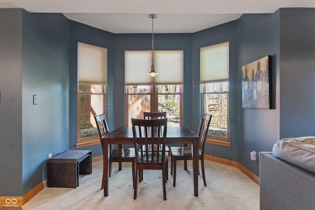dining room with light colored carpet and baseboards