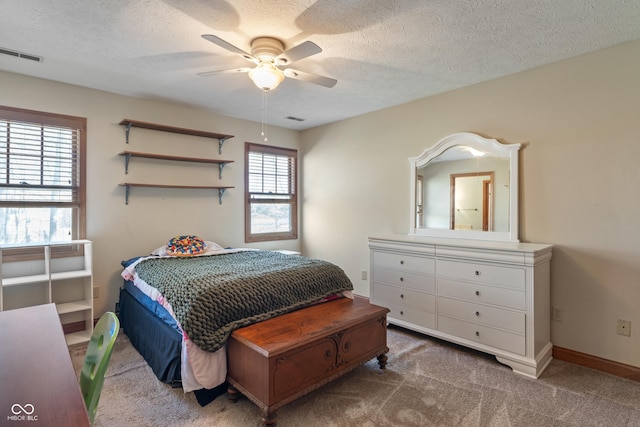 bedroom with baseboards, carpet flooring, a textured ceiling, and visible vents