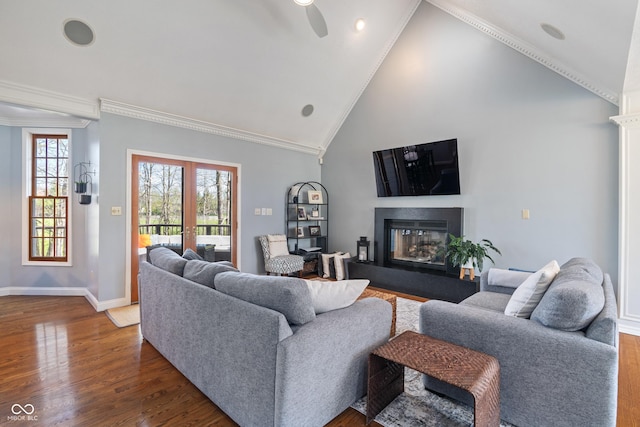 living room with crown molding, a glass covered fireplace, and dark wood-style floors