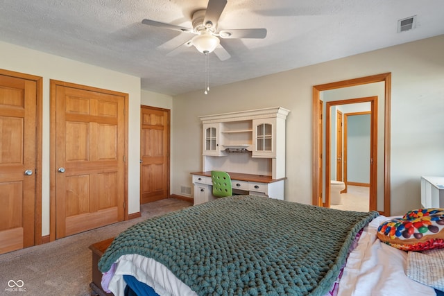 bedroom with visible vents, carpet flooring, a textured ceiling, and a ceiling fan