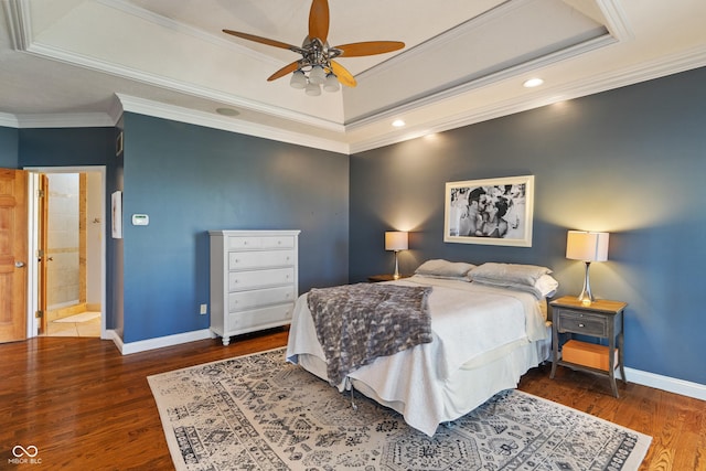 bedroom featuring baseboards, crown molding, wood finished floors, and a tray ceiling