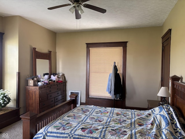 carpeted bedroom with a ceiling fan and a textured ceiling