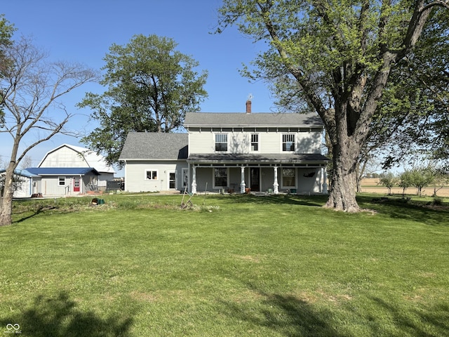 back of property featuring covered porch, a yard, and a chimney