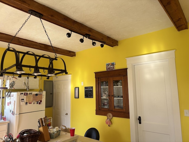 dining room featuring a textured ceiling and beam ceiling