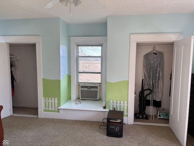 carpeted bedroom with cooling unit, a ceiling fan, and a textured ceiling