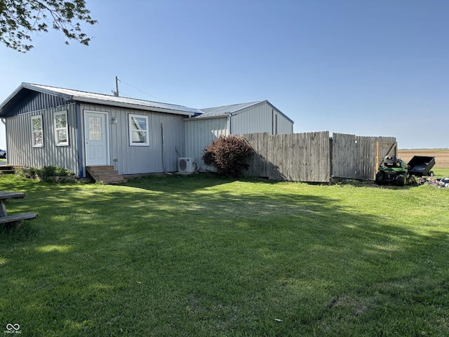 rear view of property with ac unit, fence, a yard, and entry steps
