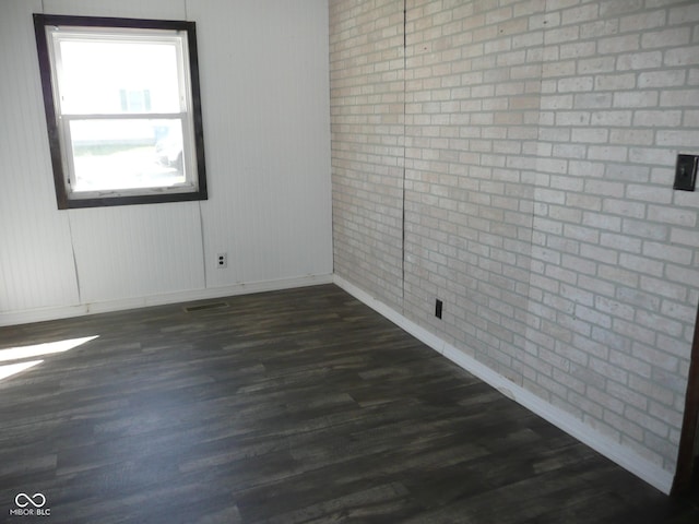215 W N G St, Gas City, IN 46933 - spare room with baseboards, dark wood-style floors, brick wall, and visible vents