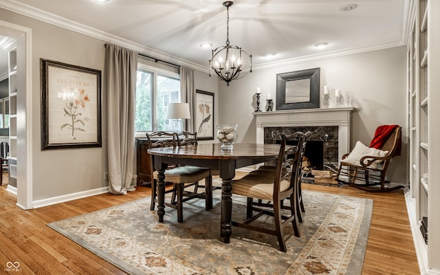 440 E 82nd St, Indianapolis, IN 46240 - dining room with a chandelier, a high end fireplace, crown molding, light wood-style flooring, and baseboards