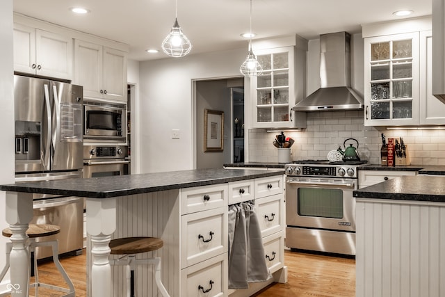 440 E 82nd St, Indianapolis, IN 46240 - kitchen featuring appliances with stainless steel finishes, wall chimney range hood, light wood-style flooring, dark countertops, and recessed lighting