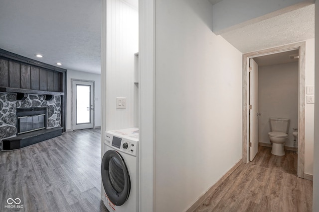 102 Clarendon Dr Unit 506, Noblesville, IN 46062 - laundry area featuring laundry area, a stone fireplace, light wood-type flooring, baseboards, and washer / dryer