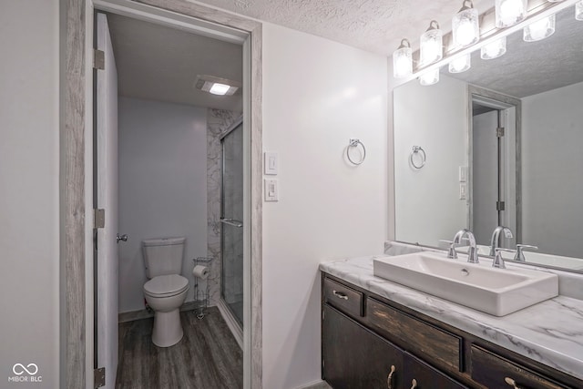 102 Clarendon Dr Unit 506, Noblesville, IN 46062 - full bathroom featuring vanity, wood finished floors, toilet, a textured ceiling, and a shower stall