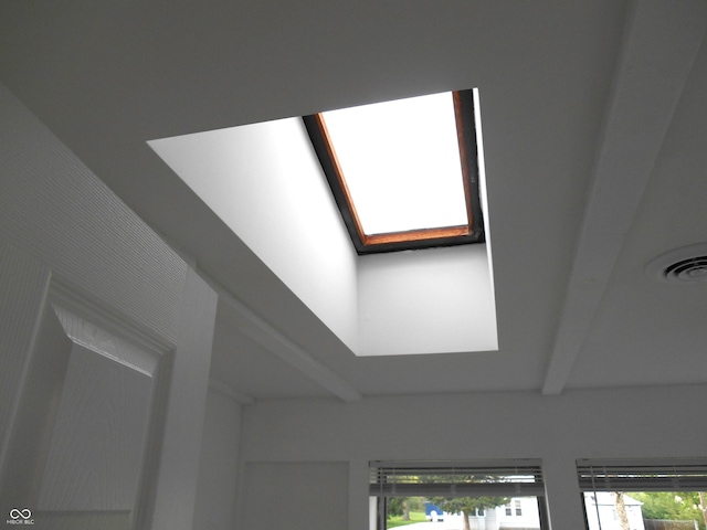 details featuring a skylight, beam ceiling, and visible vents