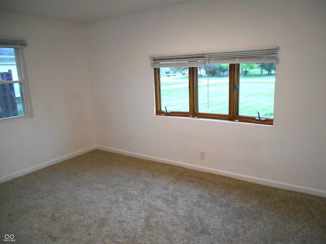 spare room featuring carpet flooring and baseboards