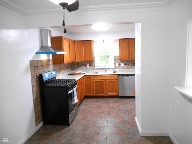 kitchen featuring appliances with stainless steel finishes, decorative backsplash, a sink, and wall chimney exhaust hood