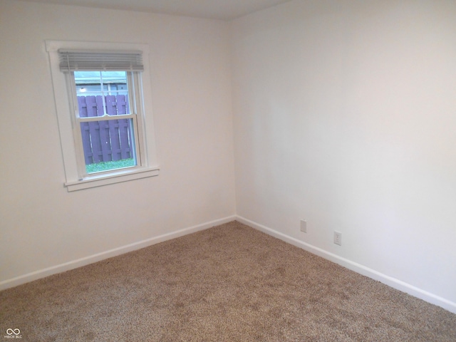spare room featuring baseboards and carpet