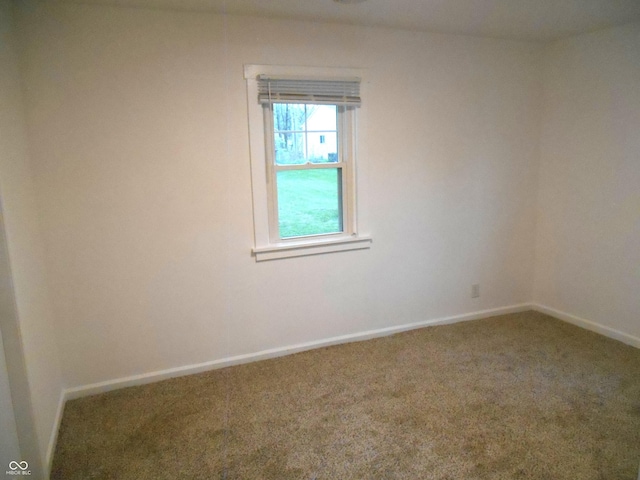 spare room with baseboards and carpet