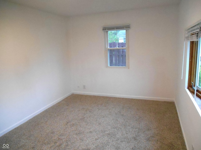 unfurnished room featuring baseboards and carpet