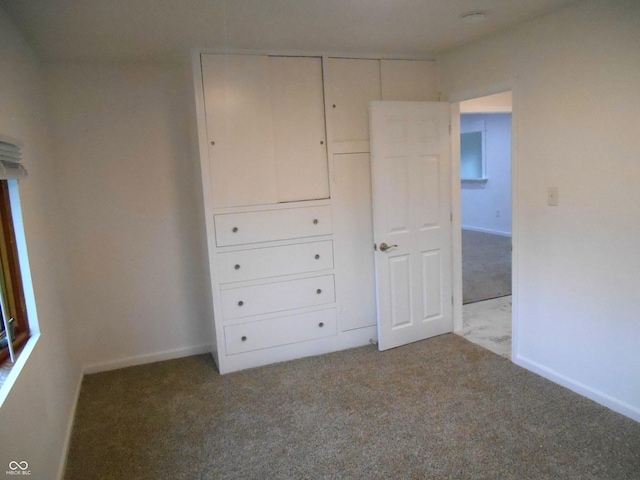 unfurnished bedroom featuring carpet flooring and baseboards