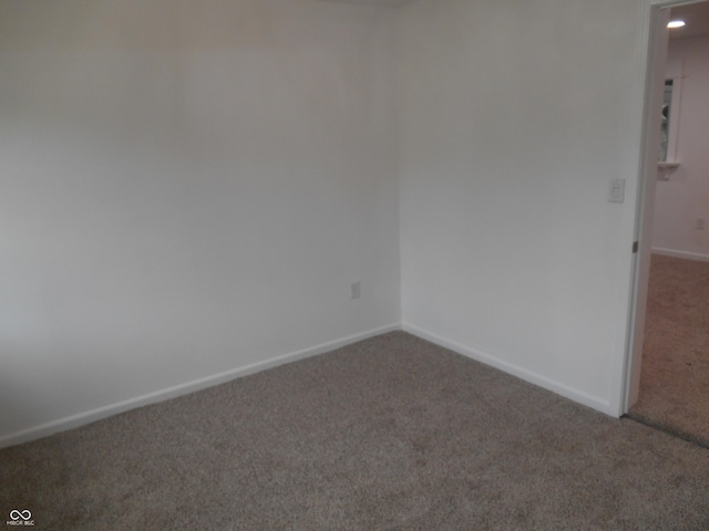 empty room with baseboards and carpet