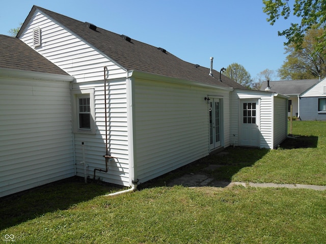 back of house with a lawn and a shingled roof