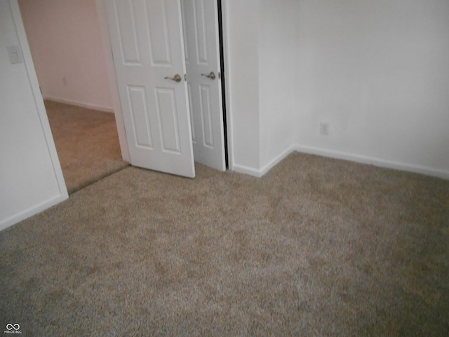 unfurnished bedroom with carpet flooring and baseboards