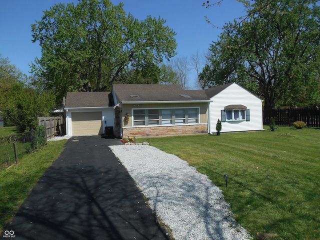 ranch-style home featuring fence, a front yard, stone siding, an attached garage, and driveway