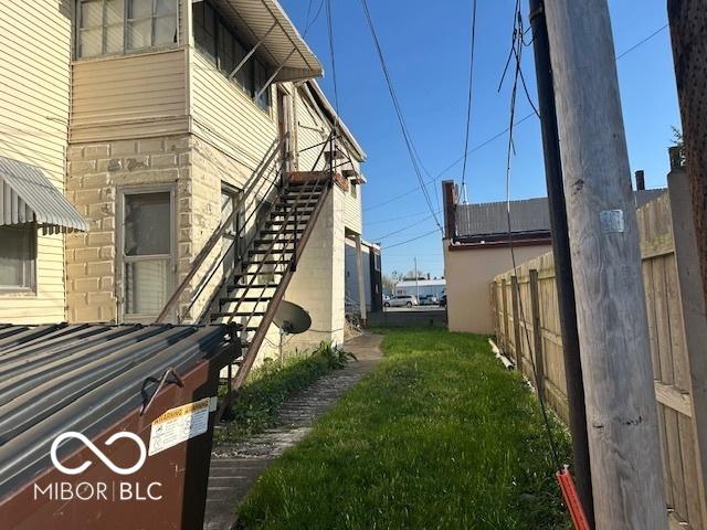 view of side of property with fence and stairway