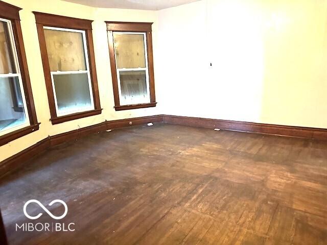 spare room featuring baseboards and hardwood / wood-style floors