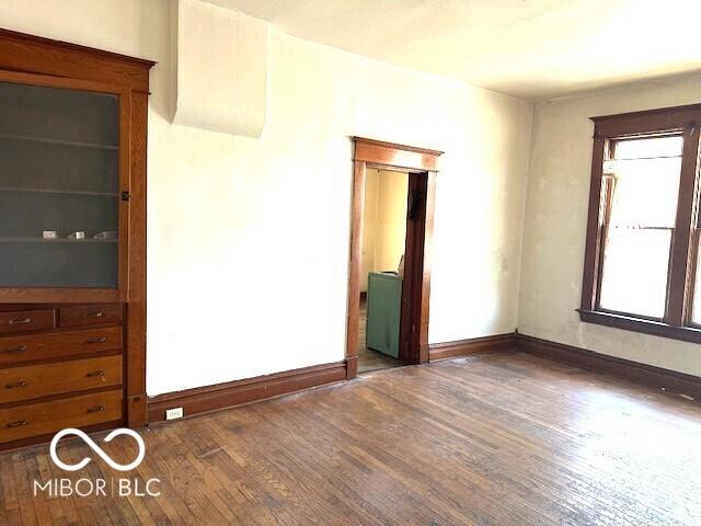 empty room featuring baseboards and wood finished floors
