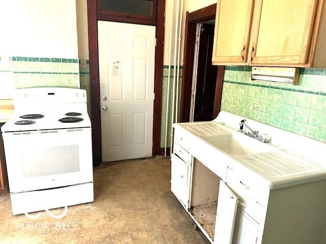 kitchen with light countertops, tasteful backsplash, and electric stove