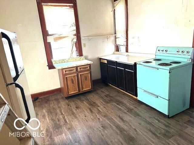 kitchen with light countertops, baseboards, dark wood-style flooring, and white appliances