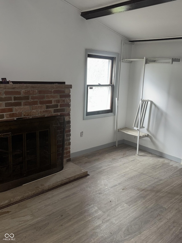 2425 S Lyons Ave, Indianapolis, IN 46241 - unfurnished living room with baseboards, a brick fireplace, and wood finished floors