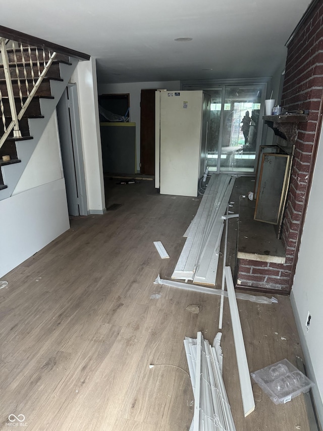 2425 S Lyons Ave, Indianapolis, IN 46241 - unfurnished living room featuring stairway, a fireplace, and wood finished floors