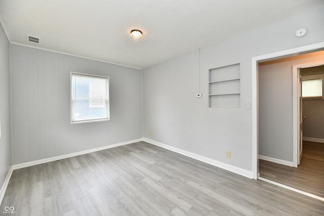 3109 Forest Manor Ave, Indianapolis, IN 46218 - spare room featuring built in features, baseboards, wood finished floors, and a wealth of natural light