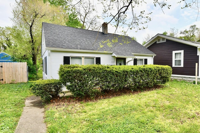 3109 Forest Manor Ave, Indianapolis, IN 46218 - exterior space with a lawn, roof with shingles, fence, and a chimney