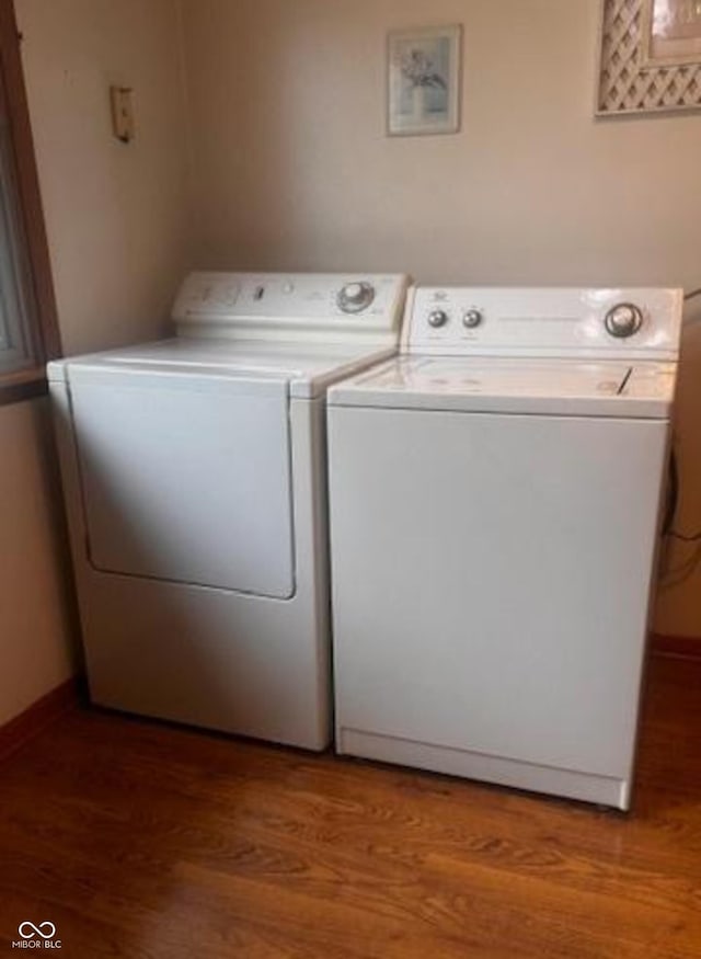 washroom featuring separate washer and dryer, laundry area, light wood finished floors, and baseboards