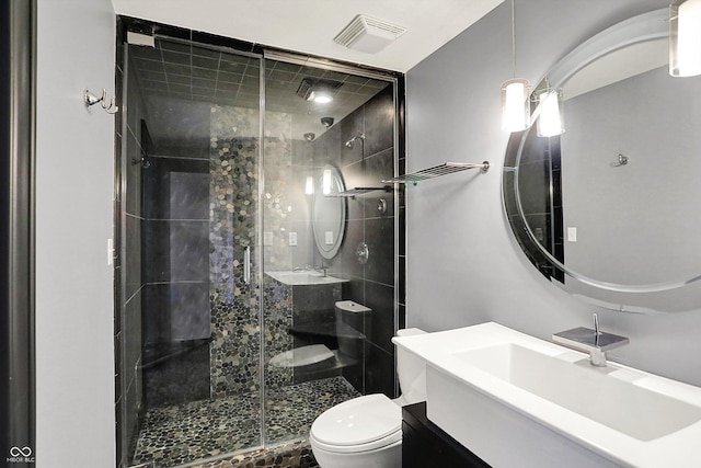 full bath with vanity, a stall shower, toilet, and visible vents